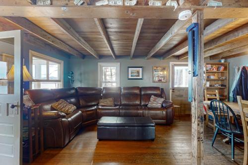 a living room with a leather couch and a table at Lakefront Living in Bomoseen