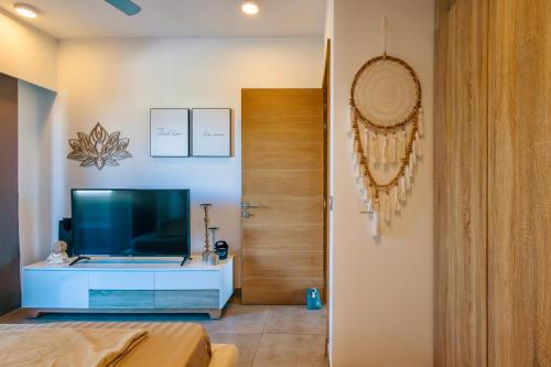 a living room with a television and a door at Luxury Penthouse with Jacuzzi, 2 min to Beach in Mont Choisy