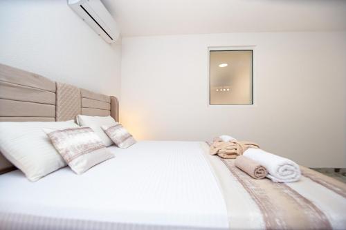 a bedroom with a white bed with towels on it at Stone Villa with pool Montenegro Star in Kaluđerac