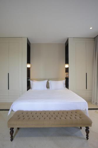 a large bed with a bench in a bedroom at L'Hôtel Particulier La Marsa in La Marsa