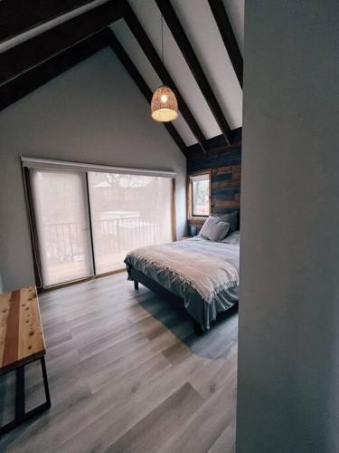 a bedroom with a bed and a large window at Refugio Andes Indómito, Las Trancas in Las Trancas