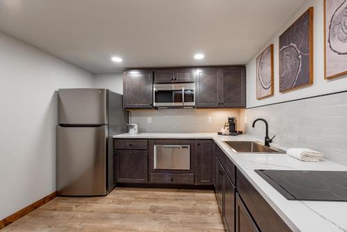 a kitchen with wooden cabinets and a stainless steel refrigerator at Cove Creek Lodge 106 Lakeside Executive King Suite in Oakland