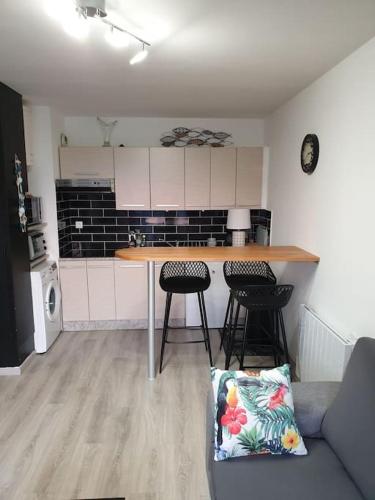 - une cuisine avec une table et deux tabourets dans une pièce dans l'établissement Le phare de Villers, à Villers-sur-Mer