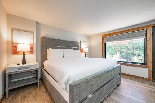 een slaapkamer met een groot bed en een raam bij Cove Creek Lodge 107 Lakeside Executive King Suite in Oakland