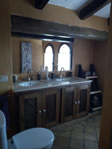 a bathroom with two sinks and a toilet at Mas Valoria in Peratallada