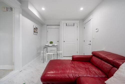 a living room with a red couch and a table at Cozy and Modern 2br guesthouse in Vancouver
