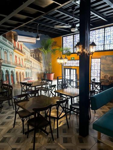 a restaurant with tables and chairs and a mural at Spartacus hostel boutique for men in Puerto Vallarta