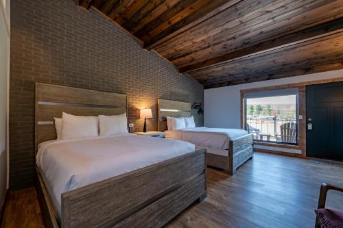 a bedroom with two beds and a large window at Cove Creek Lodge 202 Poolside Double Queen Room in Oakland
