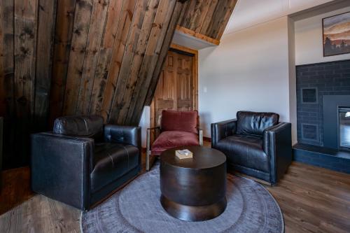 - un salon avec deux fauteuils en cuir et une table dans l'établissement Cove Creek Lodge 204 Poolside Double Queen Fireplace Room, à Oakland