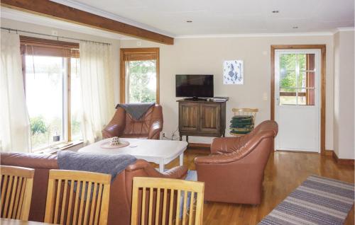 a living room with a couch and a table and chairs at 3 Bedroom Lovely Home In Gällstad in Holmared