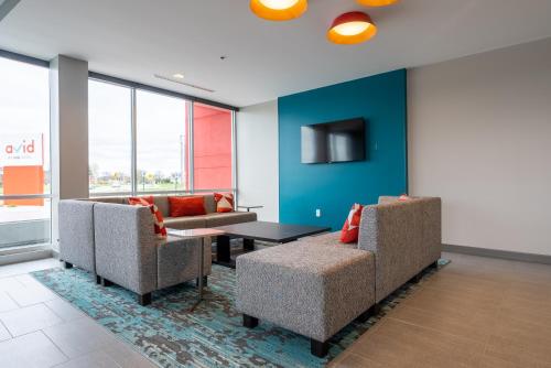 a living room with two chairs and a table at avid hotels - Kalamazoo East by IHG in Kalamazoo