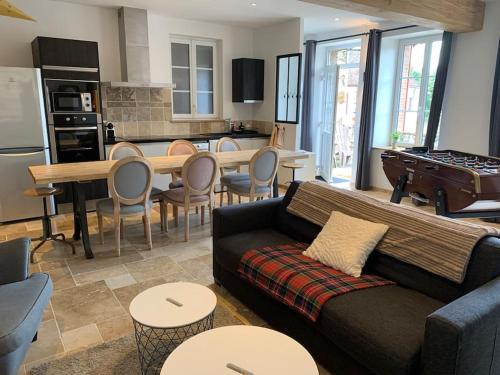 un salon avec un canapé et une table et une cuisine dans l'établissement Pantouflard - Maison entière, à Toucy