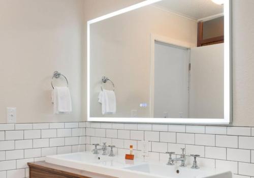 a white bathroom with a sink and a mirror at Sapphire Motel Midtown Bozeman in Bozeman