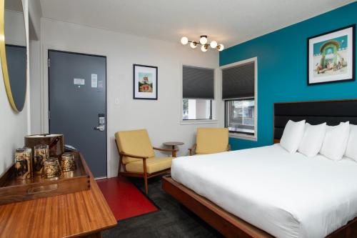 a hotel room with a bed and a table and chairs at Sapphire Motel Midtown Bozeman in Bozeman