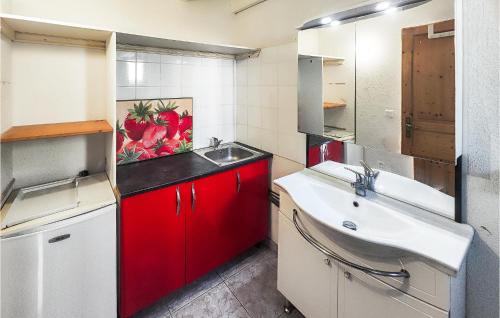 a small kitchen with red cabinets and a sink at Beautiful Home In Servian in Servian