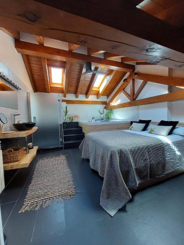 a bedroom with a large bed and a kitchen at Lo Attic in Sort