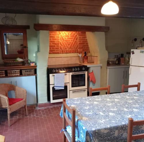 a kitchen with an oven and a table with a table sidx sidx at Chez Johns in Bailleul-Neuville