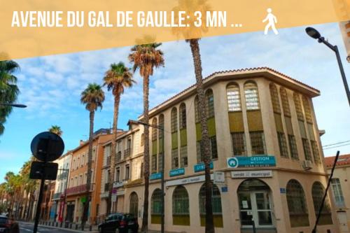 a building on a city street with palm trees at Le Cosy Perpignan Centre, 2 rooms, 2 bathrooms, free WIFI, free parking, lift, central, renovated, spacious in Perpignan