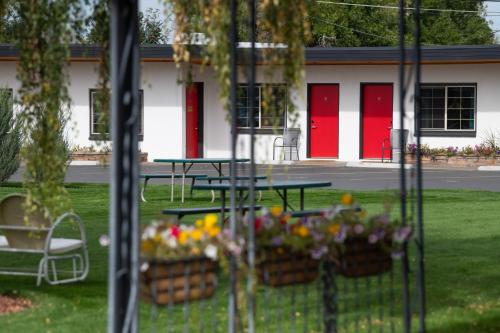 a picnic table in a yard with flowers in the grass at Sapphire Motel Midtown Bozeman in Bozeman