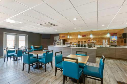 Best Western Plus Sun Canyon في سييرا فيستا: مطعم فيه كراسي زرقاء وطاولات ومطبخ