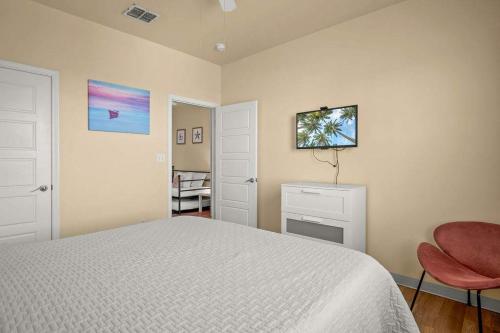 a bedroom with a bed and a chair and a television at 3 Br Padre Isl Retreat Min to Beach Dog Friendly in Padre Island