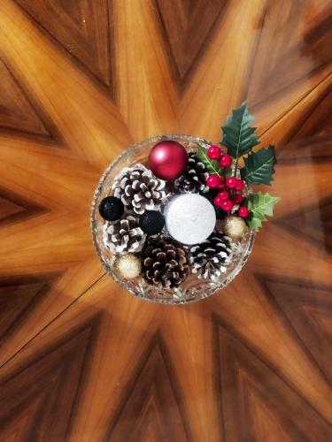 a bowl of christmas decorations on a wooden floor at Διώροφο πέτρινο σπίτι με θέα Agiasos Classic Stone House in Agiásos