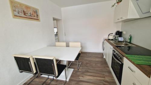 a small kitchen with a white table and chairs at Fewo Peter Erholungsort Bärenstein in Bärenstein