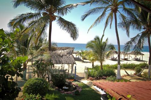 a view of a beach with palm trees and the ocean at Hotel Gilda in Coyuca