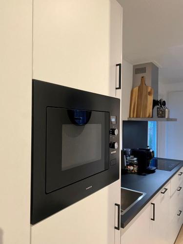 a microwave oven in a kitchen with a counter at Natuurlijk huisje Sallandse Heuvelrug in Haarle