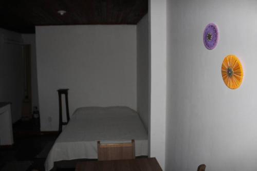 een slaapkamer met een bed en een klok aan de muur bij Kitnet Praiano- Praia de Olaria in Majé