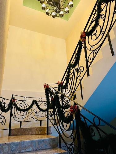 a staircase with a wrought iron railing with flowers on it at Casa Hotel Marchel in Tequila