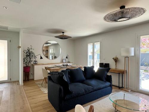 un salon avec un canapé bleu et une table dans l'établissement Le Nid Ruthénois - Clim, Wifi, Netflix & Terrasse, à Rodez