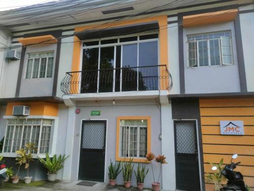 a white and orange house with a balcony at JMC1 Room1 Tagbilaran City Bohol in Tagbilaran City