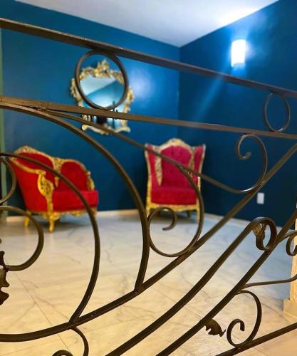 a bedroom with two red chairs and a mirror at Casa Hotel Marchel in Tequila