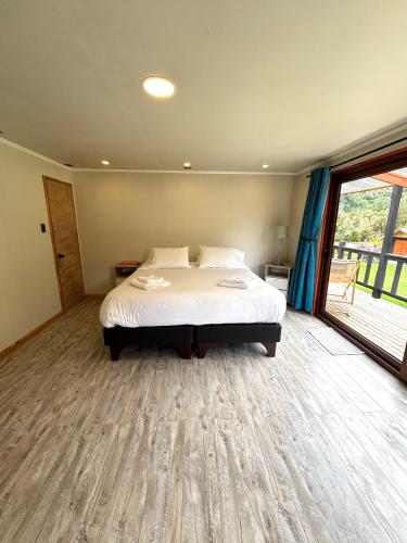 a bedroom with a bed and a large window at Hotel Neyün La Junta in La Junta