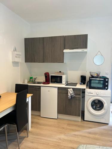 Il comprend une cuisine équipée d'une cuisinière et d'un lave-linge/sèche-linge. dans l'établissement Studio vu parc des Célestins, à Vichy