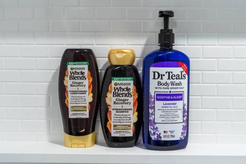 three bottles of hair products sitting on a shelf at Cozy 3BR Haven in Hillsdale