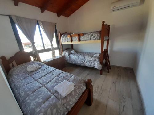 a bedroom with two bunk beds and a window at Cabañas Altos de Kamiâre in Villa Yacanto