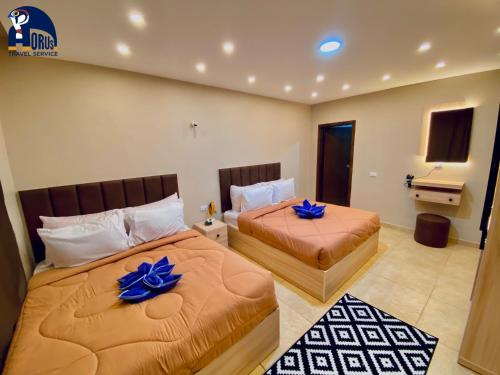 two beds in a hotel room with blue flowers on them at Horus The Horizon Pyramids View in Cairo