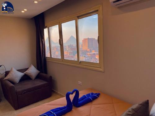a living room with a couch and a window at Horus The Horizon Pyramids View in Cairo