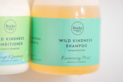 two bottles of wild kindness shampoo andromycin on a table at The Lodge at Bow Lake in Lake Louise