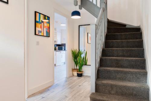 a staircase in a home with white walls and wood floors at 5 Bed House Sleeps 9 Parking Garden Pet Friendly in Sileby in Sileby