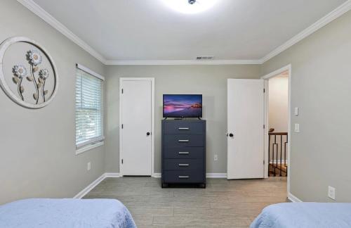 a bedroom with a bed and a dresser with a tv at #81 Beautiful Large 2 Assigned Parking Pool Pet Friendly Near All in Hilton Head Island