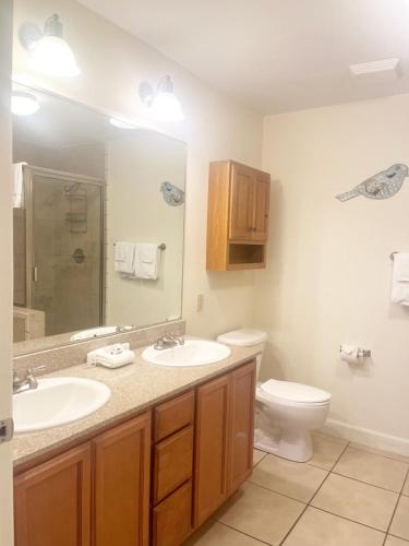 a bathroom with two sinks and a toilet and a mirror at Unit 5106 - Mountain View Condos - Free Attraction Ticket including Dollywood in Pigeon Forge