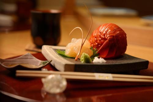 a piece of food on a plate on a table with chopsticks at Sheraton Grand Taipei Hotel in Taipei