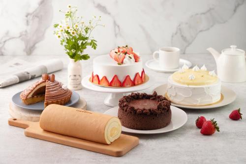 a table topped with cakes and desserts on plates at Sheraton Grand Taipei Hotel in Taipei