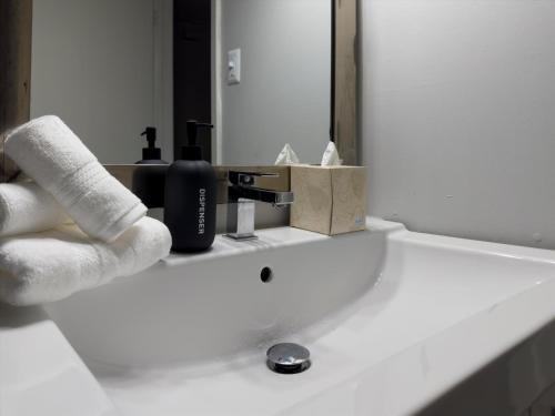 w łazience znajduje się umywalka z ręcznikami i lustro w obiekcie Mins 2 Downtown - King Bed - Private Stays w mieście Austin