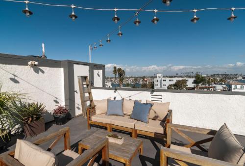 a patio with chairs and tables on a roof at 50 M to Sand LGB 2 King Suites in Long Beach