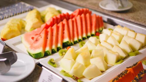 a bunch of different types of food on plates at Interludium Iguassu Convention Hotel in Foz do Iguaçu