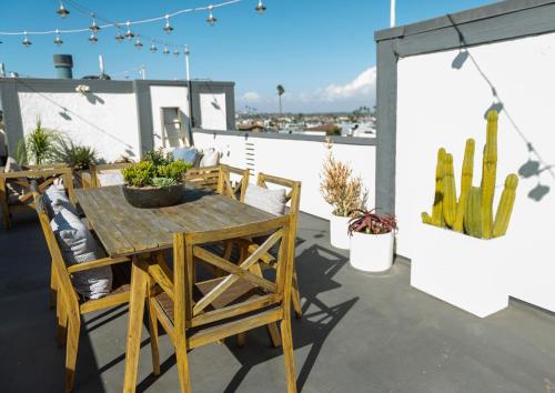 a wooden table and chairs on a patio with cactus at 50 M to Sand LGB 2 King Suites in Long Beach